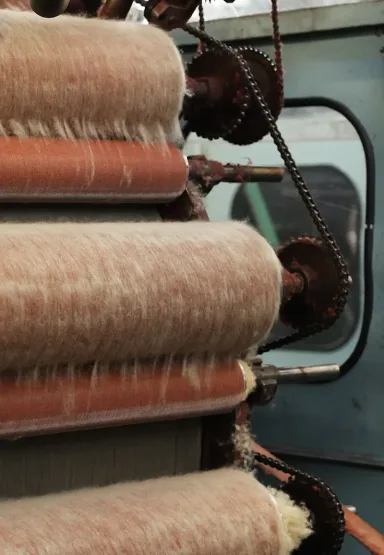 Johnstons of Elgin Carding Machine with natural fibres on the rollers, photographed in our Elgin Mill